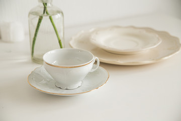 white cup and saucer on white table