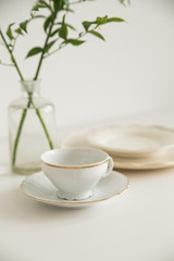 white cup and saucer on white table