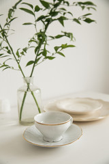 white cup and saucer on white table