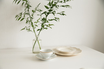 white cup and saucer on white table
