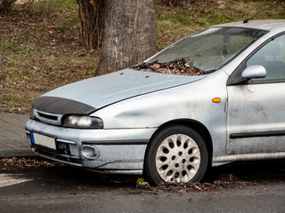 Fototapeta na wymiar Light blue car damaged in a slight traffic accident with a flat tyre