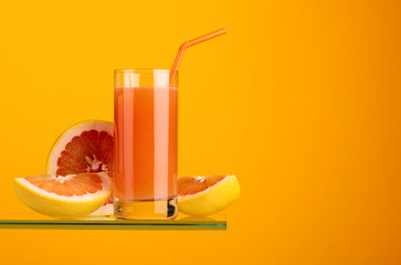 Glass of fresh grapefruit juice with fresh fruits.