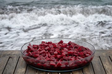 Boiled beetroot  served in a glass bowl on a wooden table near the sea side