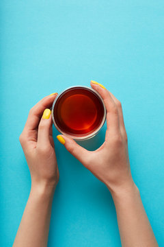 Hands holding a glass of tea