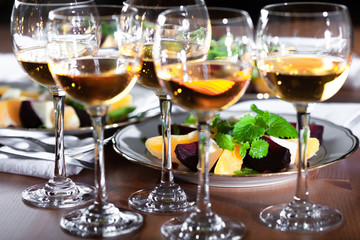 Set of wineglasses and plates with salad in the beautifull light