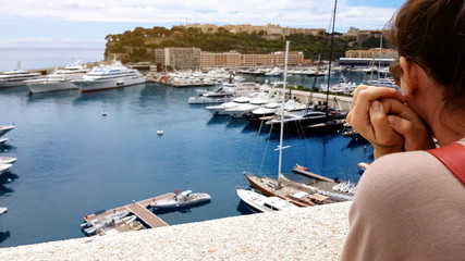 Girl in worn clothes looking at expensive ship, gap between rich and poor