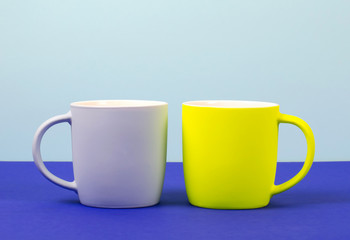 Bright new cups on a solid pastel background.