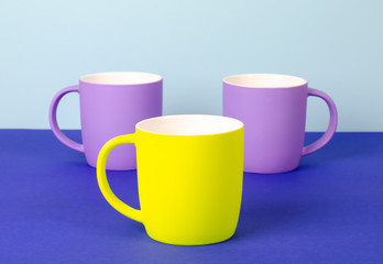 Bright new cups on a solid pastel background.