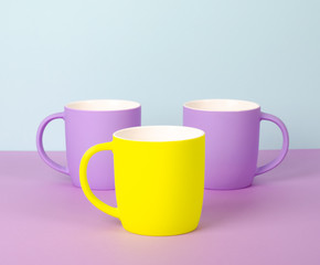 Bright new cups on a solid pastel background.