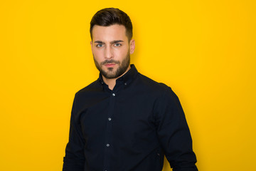 Fototapeta premium Handsome young hispanic man posing as model over isolated yellow background