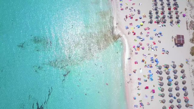 Aerial view of beautiful Mallorca beach, Cala agulla. Flight above beach umbrellas.