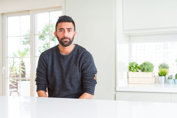 Fototapeta premium Handsome hispanic man wearing casual sweater at home depressed and worry for distress, crying angry and afraid. Sad expression.