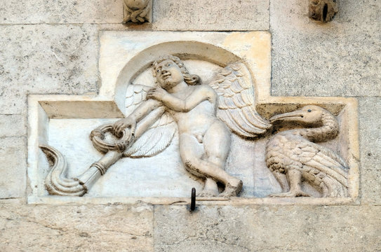Genio Funerario with upside-down torch (around 1099), bas-relief by Wiligelmo, Modena Cathedral, Italy 