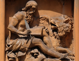 Saint Mark the Evangelist relief on house facade in Modena, Italy 