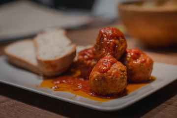 Pork meatballs with glaze and tomato sauce , heart shaped bread slices in a white plate.