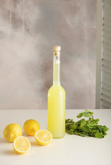 Bottle of homemade juice with mint and lemon on light background. Vertical