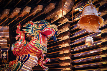 Fototapeta premium Dragon and the bell, symbols of buddhist religion, under the roof of old medieval wooden buddhist temple in Nikko, Japan.