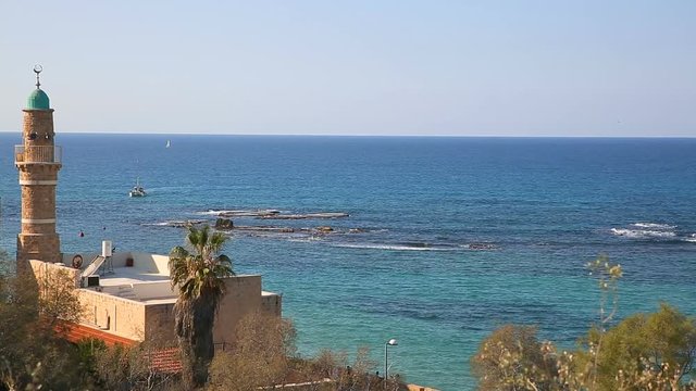 White yacht moving on Mediterranean sea behind minaret background