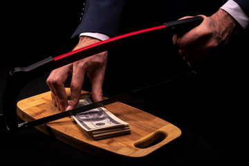 A man in an expensive suit "saws" government money. Concept on corruption theme