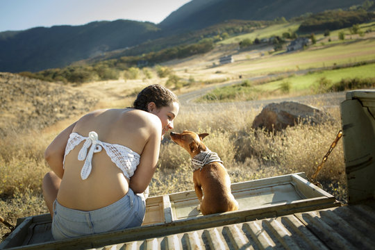 Young woman touches noses with pet chihuahua