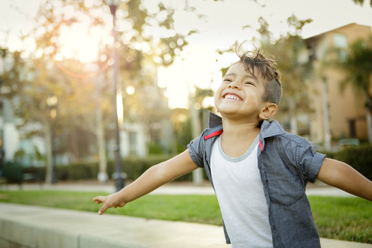 Young boy with mohawk spreads his arms and smiles