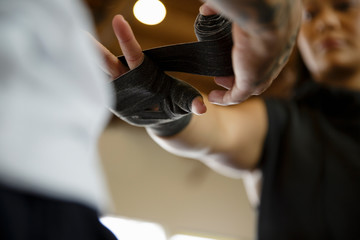 Trainer wraps woman boxer's hand