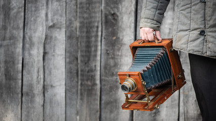 Large format retro camera in photographer hand. Concept - photography of the 1930s-1950s. Retro...