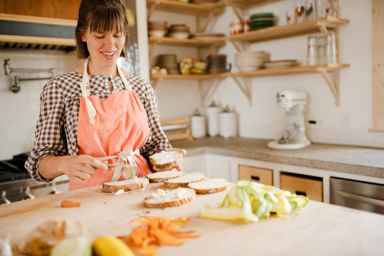 Woman buttering bread in kitchen