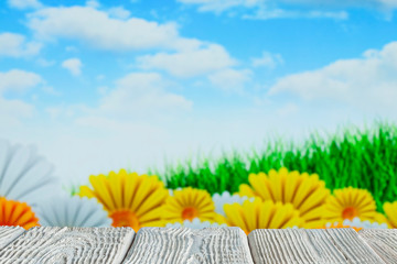 White wooden table with free space on nature background - flowers, grass and blue sky