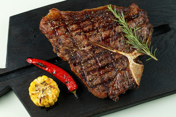 steak fried tibon with corn on the table.