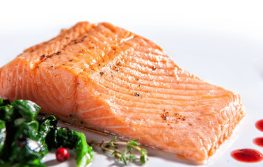 A piece of steamed salmon steak with spinach