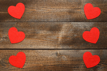 Red hearts on brown wooden background