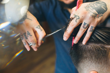 Confident bearded man visiting hairstylist in barber shop.