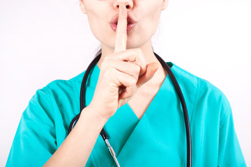 Young nurse woman over isolated background asking to be quiet with finger on lips. Silence and secret concept