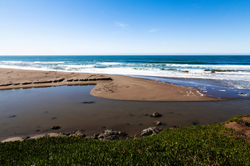 Fresh Water Flowing Across Beach To Ocean Blue Sky