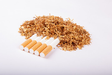 Papierosy przysypane tytoniem na białym tle