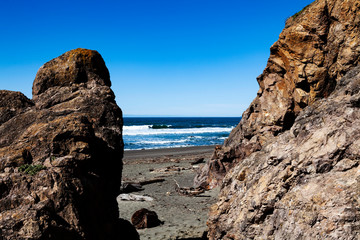 View Of Ocean Between Cliff And Rock With Blue Sky