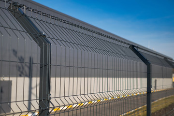 Steel grating fence made with wire on blue sky background. Sectional fencing installation