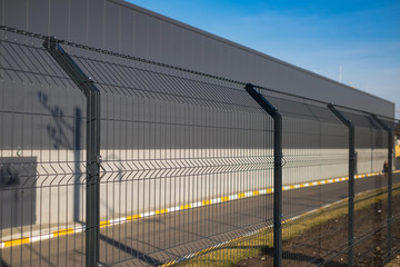 Steel grating fence made with wire on blue sky background. Sectional fencing installation