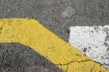 Asphalt surface texture detail with old parking white yellow paint