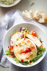 Salad with lettuce, fried pears, camembert, walnuts, red onion, tomatoes and raspberry vinaigrette dressing