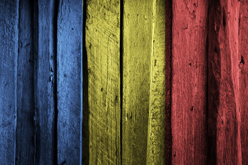 Romanian flag on background of old wooden planks.