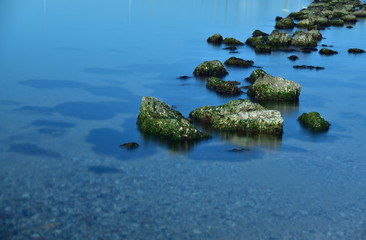 steine im glatten wasser bilden einen weg vom betrachter weg