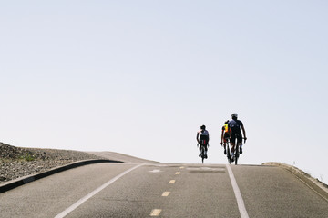 Rear view of cyclist riding bicycle on road