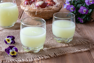 Two glasses of fresh whey with pansy flowers