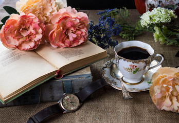 Cup of coffee old poeltry book and peon