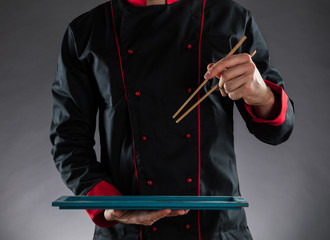 Master chef holding chopsticks and plate