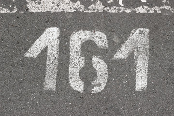 Parking lot asphalt stencil number 161 street sidewalk