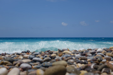 Clear azure wave covers Natural Round Pebbles On The Beach