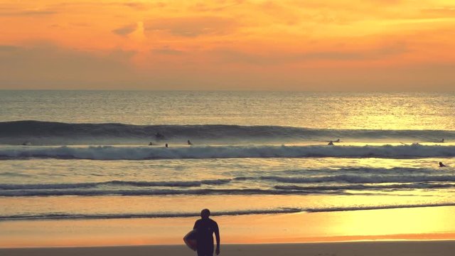 Carcavelos beach, one of the most famous Lisbon beaches, at sunset during winter,surfers riding a medium wave.Golden hour.